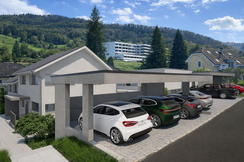 Modern residential building with multiple covered parking spaces in front of the house, white house, modern design, trees and mountains in the background.