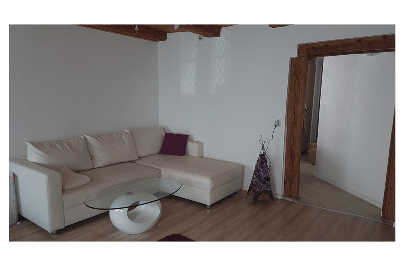 white couch, white table, grey wall, brown flooring