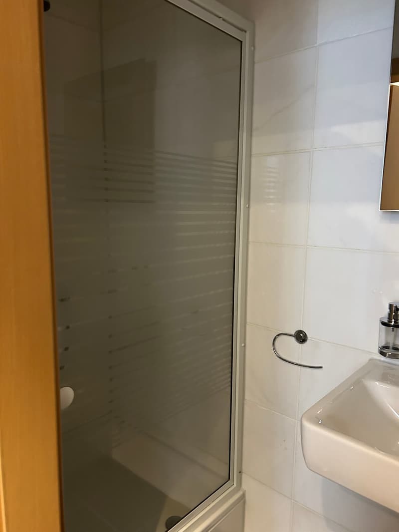 Bathroom with shower, sink, and mirror