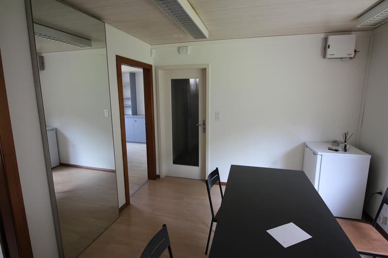 empty room, with desk, chairs, mirror, small kitchen and bathroom
