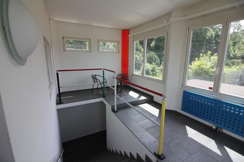modern staircase, handrails, chairs, table, radiator, windows, trees outside