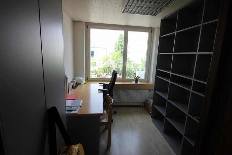 desk, two chairs, bookshelf, window, plant, bag
