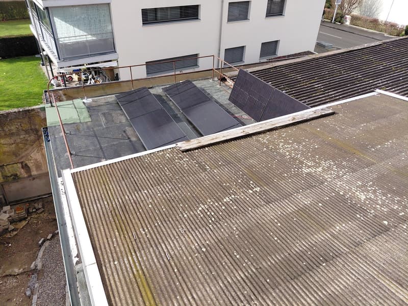 Roof with solar panels and rusted metal cladding