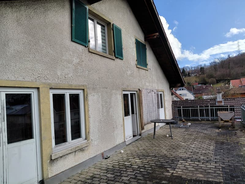 Cobblestone paved courtyard, entrance doors, green shutters, table, metal railings