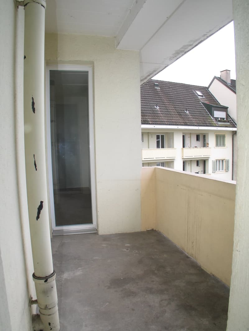 Empty balcony with closed door, grey floor