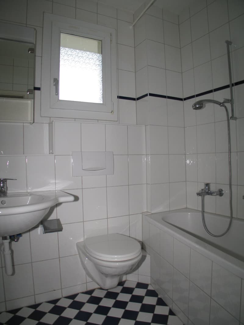 Bathroom with bathtub, toilet, sink, and shower.