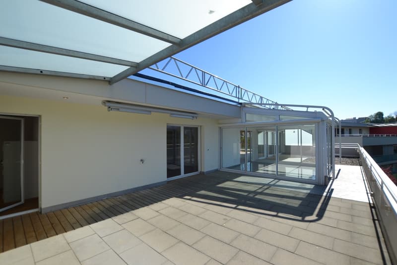 covered balcony with wooden floor, glass walls, metal railings