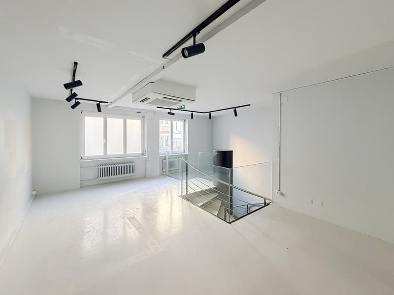 minimalist, large room, white walls, ceiling lights, large windows, large staircase