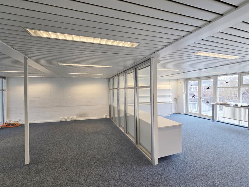 white walls, gray flooring, sliding glass doors, white desk, multiple windows
