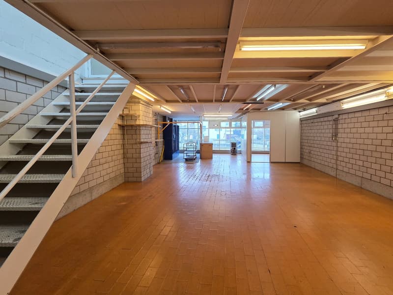 empty room, wooden floor, brick walls, white walls, staircase, fluorescent lighting