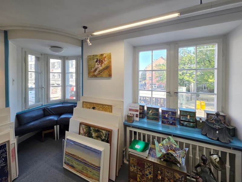 art gallery, paintings, sculptures, radiator, couch, windows