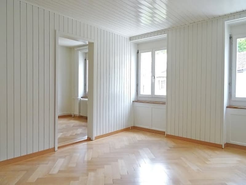 empty room, wooden floor, white walls, white ceiling, windows, radiator