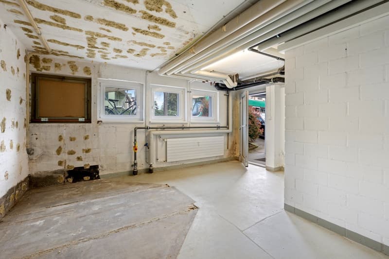 empty room, white walls, concrete floor, windows, pipes, radiator, open door