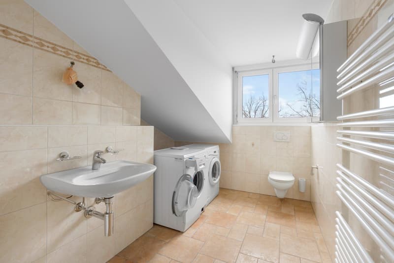 Small bathroom with washing machine, sink, toilet, and window
