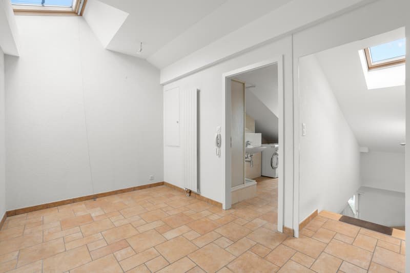 empty room, white walls, tiled floor, two windows, door to bathroom, door to staircase