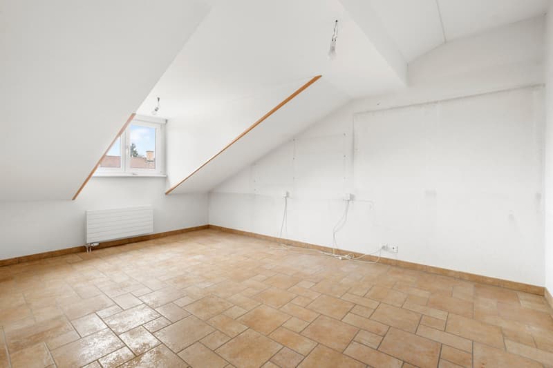 empty room, white walls, wooden floor, small window, slanted ceiling