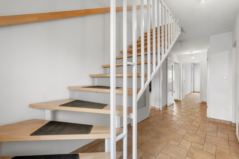 wooden staircase, tiled floor, white walls, open doorways