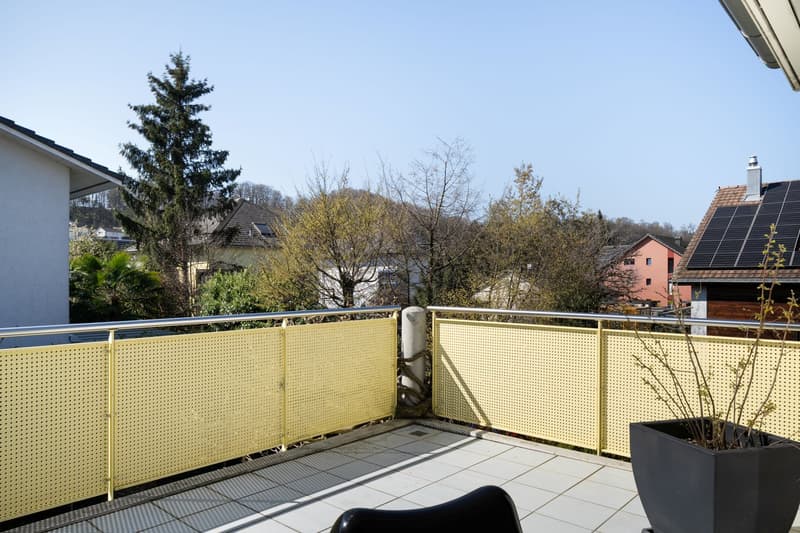 yellow metal railing, tiled floor, black chair, potted plant