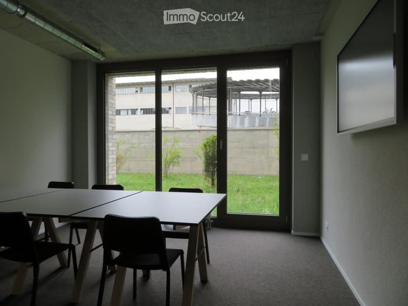 empty room with tables and chairs, large glass doors, view to garden and buildings