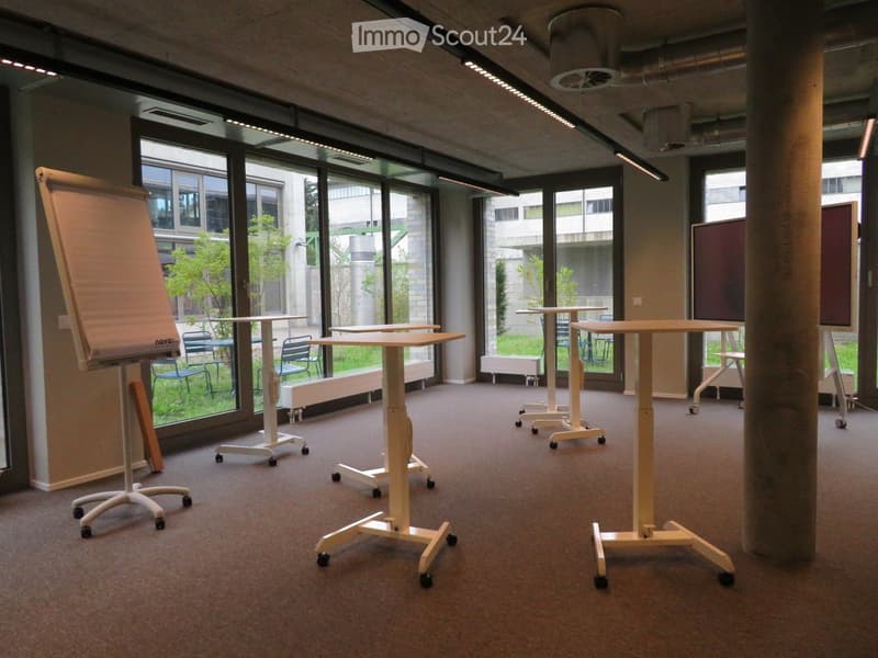 modern meeting room with adjustable height desks, large windows, whiteboard, projectors, movable chairs, carpet flooring