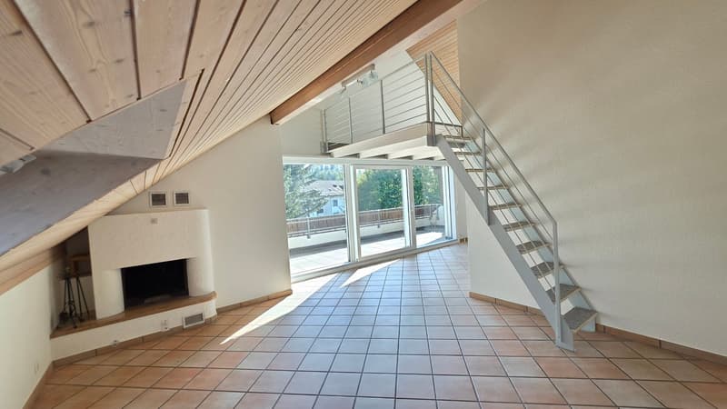 Wohnzimmer mit Cheminée und Aufgang zur Galerie
