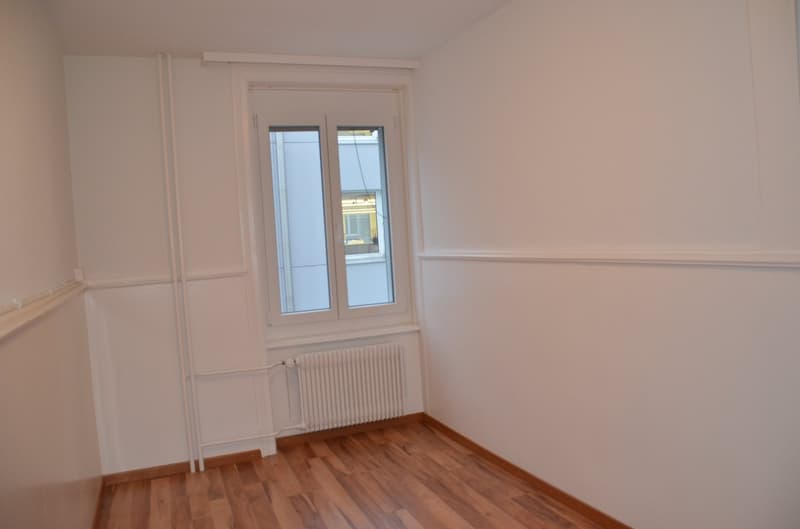empty room, white walls, wooden floor, window, radiator