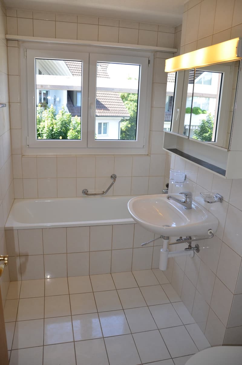 Bathroom with bathtub, sink, mirror, and toilet