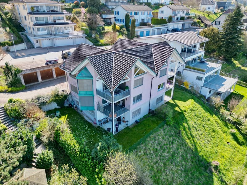 Luftansicht 4-Familienhaus über dem Dorf eingebettet in den Hang