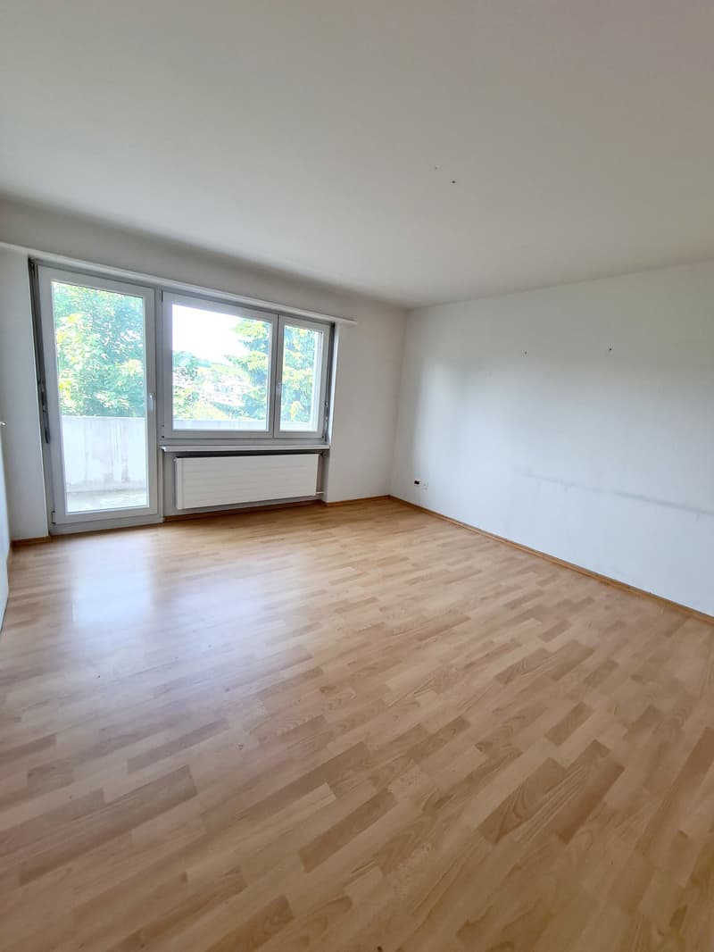 Spacious bedroom with large windows, hardwood flooring, and access to a balcony or terrace.