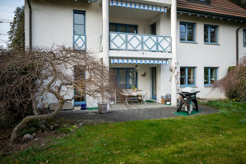 2 story house, white exterior, blue trim, brown roof, balcony, outdoor table, grill