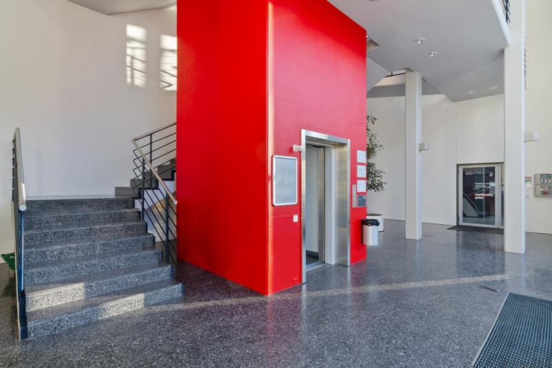 grey tiled floor, red pillar, stairs, elevator