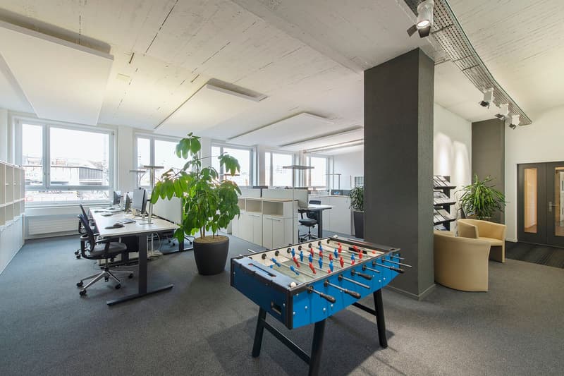 large window, desk, chairs, potted plants, foosball table, bookcase