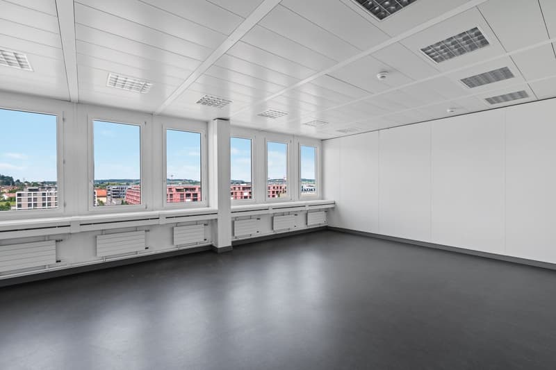 large windows, ceiling mounted security cameras, modern design, grey flooring, white walls