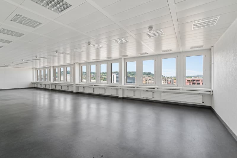 modern, minimalist room with white walls and ceiling, large windows, grey floors, built-in heating elements along walls