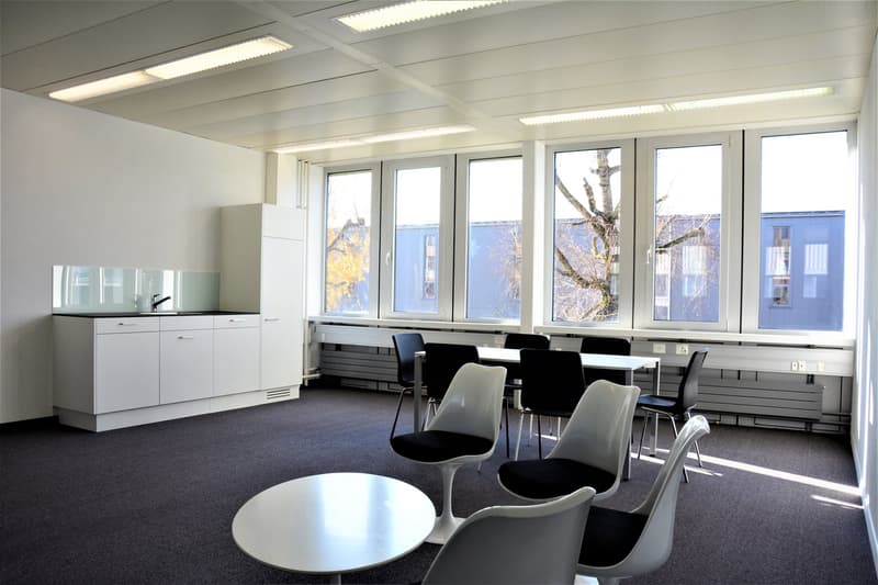 kitchen area with white cabinets, table, chairs, windows