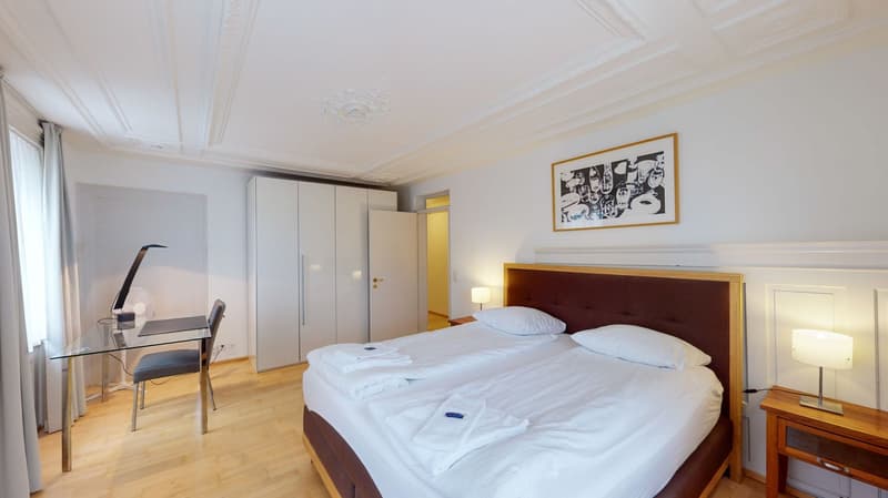 bedroom with two single beds, wardrobe, picture frame, glass desk, chair, two lamps