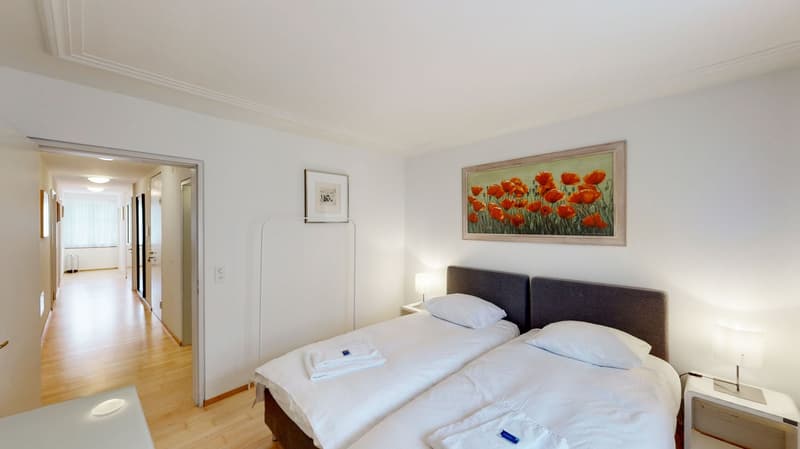 double bed, wooden floor, bedside tables, lamps, painting, door