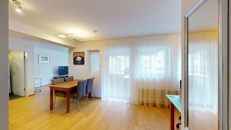 Dining room, hardwood floor, wooden table and chairs, TV, radiator, windows, sliding curtains