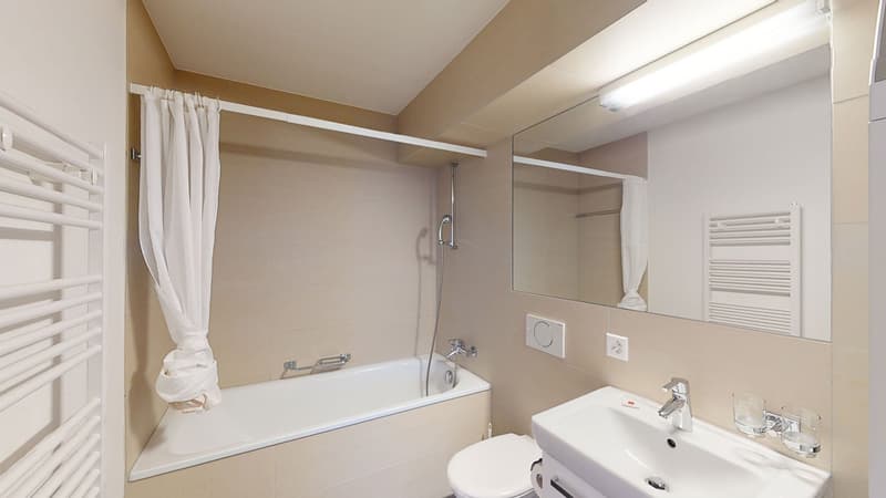 Bathroom with bathtub, sink, toilet, mirror, and towel rack