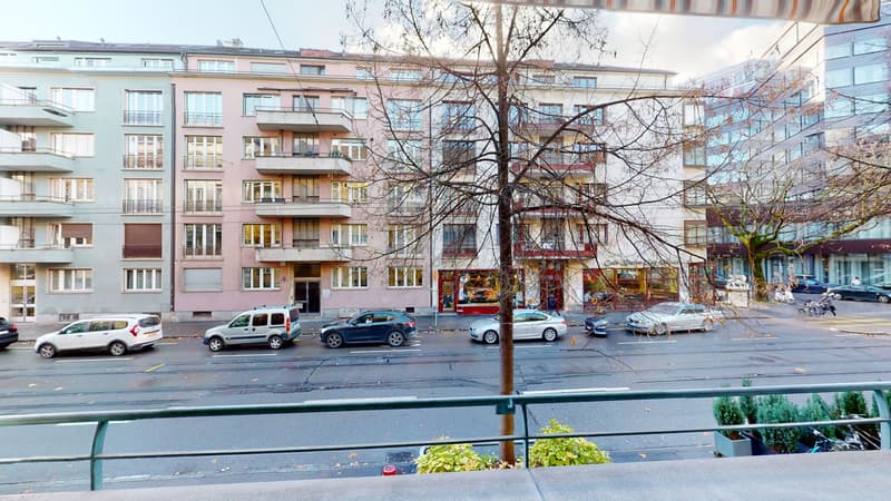 multiple story building, numerous balconies, street view, cars parked in front