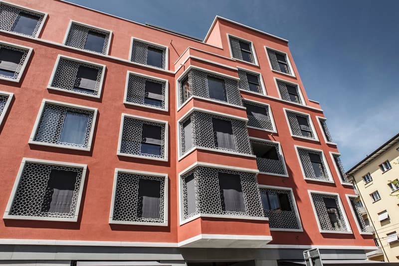 Red facade, large windows, balconies