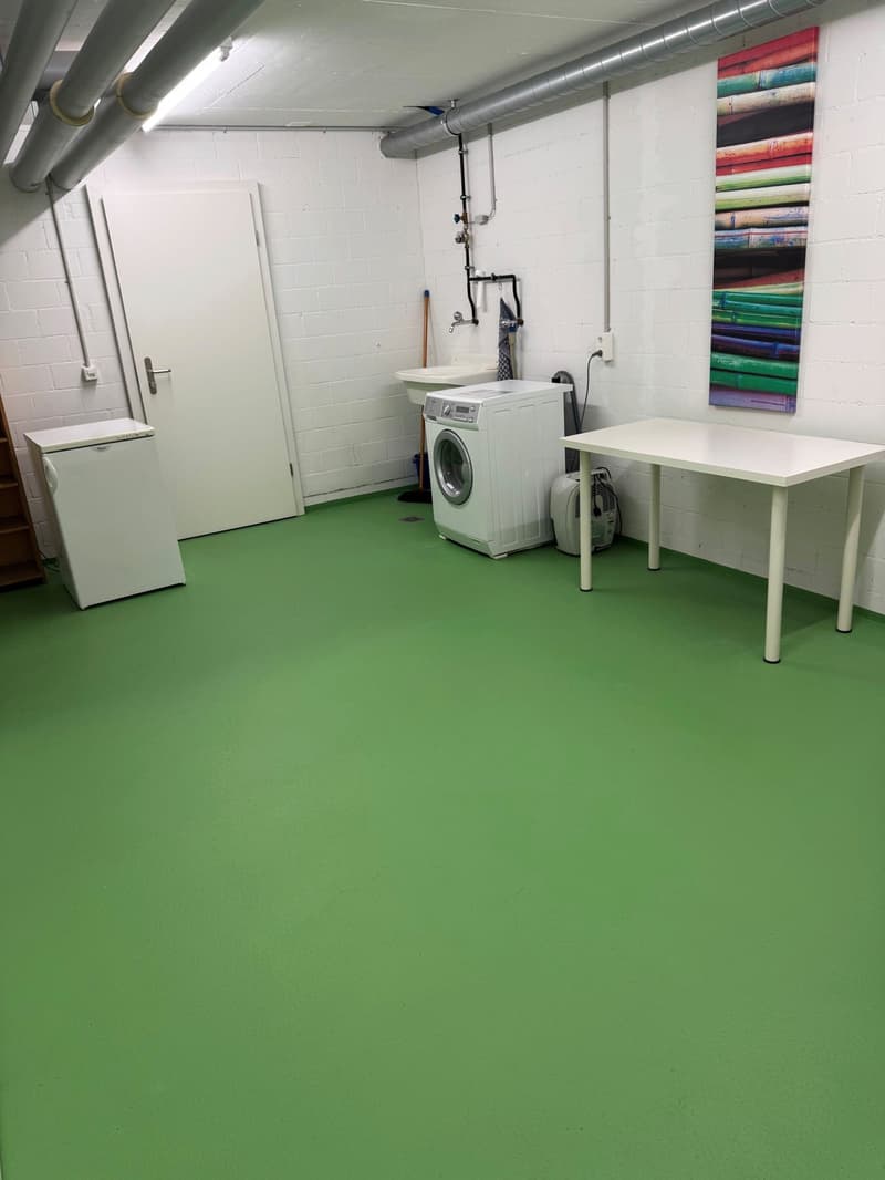 Laundry room with washing machine, sink, table, and refrigerator