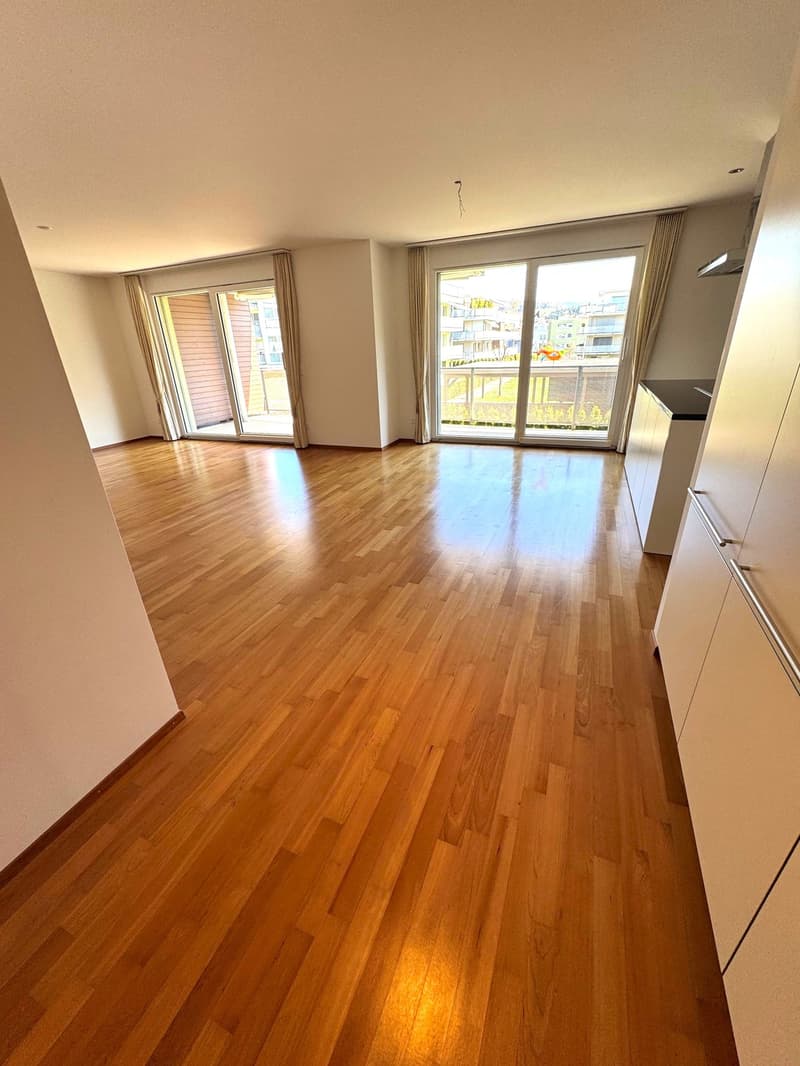 empty room, wooden floor, sliding glass doors, balcony, white walls, white cabinets
