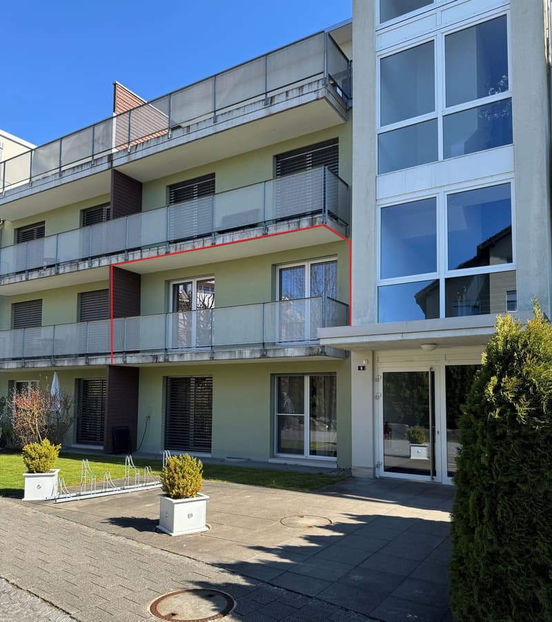 3 story building, balconies, glass windows, entrance, plants