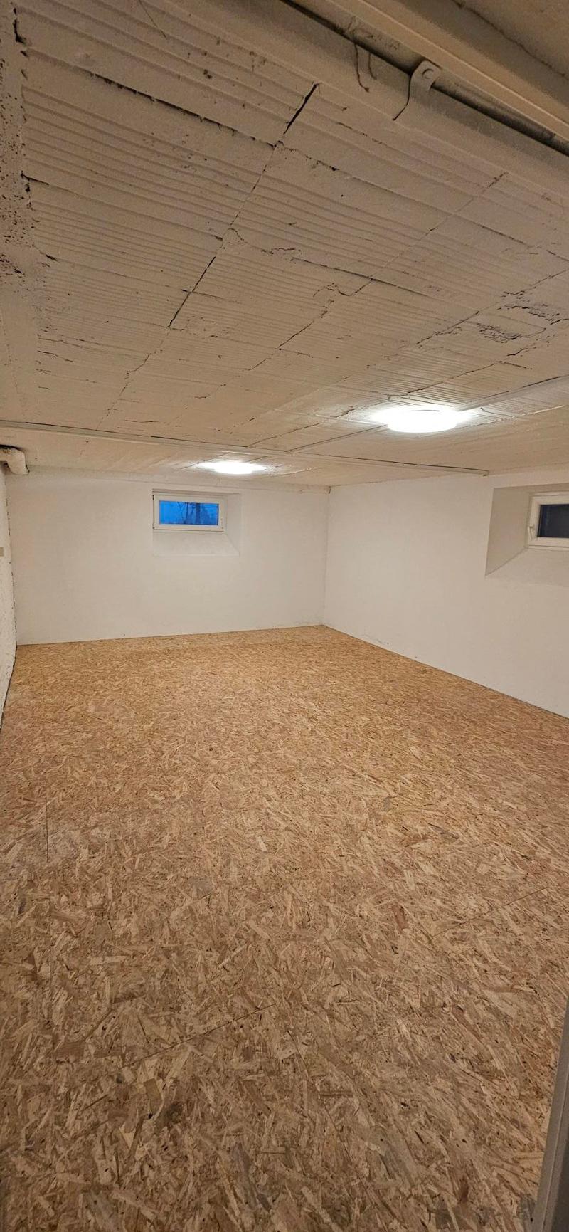 empty room, wooden floor, two small windows, two ceiling lights