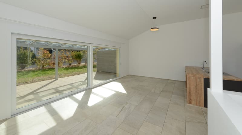 Blick in den Wohnbereich mit dem gedeckten Sitzplatz
