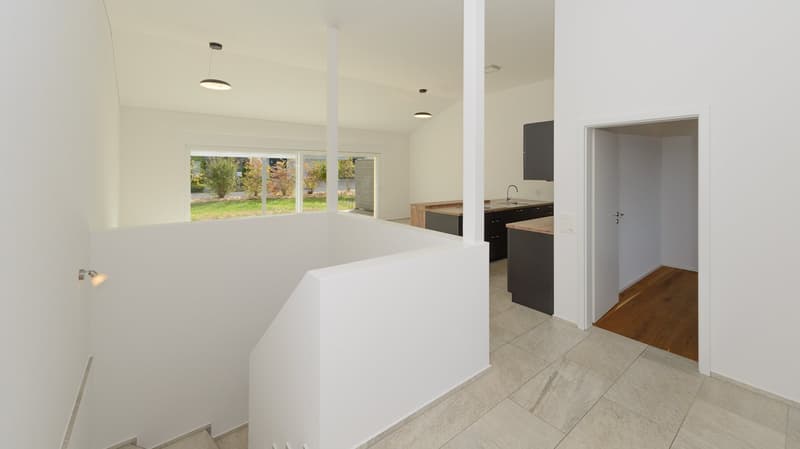 Blick vom Entrée in den Wohnbereich mit dem Büro rechts