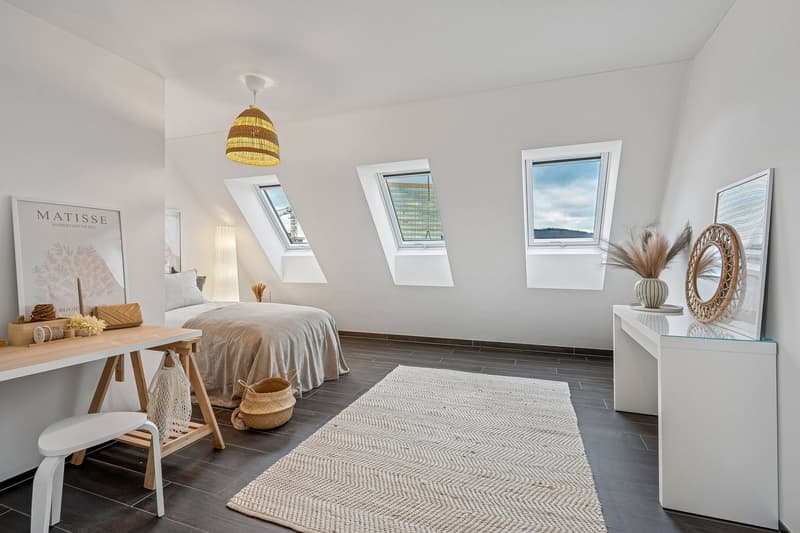 bedroom with double bed, desk, stool, lamp, baskets, rug, wall-mounted lamps, framed posters, windows