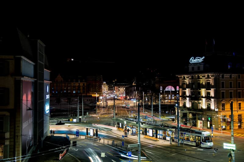 Urban street scene at night with tram, buildings, and traffic lights