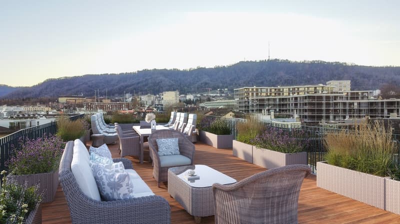outdoor seating area, coffee table, flowerpots, mountain view